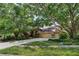Charming single-story home featuring mature trees, lush landscaping, and a spacious driveway leading to a three-car garage at 17321 Oak Ledge Dr, Lutz, FL 33549