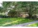 Charming home exterior with a lush green lawn and mature trees at 17321 Oak Ledge Dr, Lutz, FL 33549