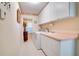 Bright laundry room with washer, dryer, white cabinets, and tiled floor at 17321 Oak Ledge Dr, Lutz, FL 33549