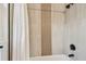 Elegant shower with neutral tile, modern fixtures, and a shower curtain at 1750 Dayton S St, St Petersburg, FL 33712