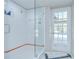 Bathroom shower features clear glass doors, a white tiled wall with colorful sailboat accents, and a view to the pool at 17917 Clear Lake Dr, Lutz, FL 33548