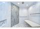 Beautiful walk-in shower with gray and white tiles, a shower bench, and grab bars at 17917 Clear Lake Dr, Lutz, FL 33548