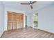 This is a bedroom with wood floors, a ceiling fan, louvered closet doors, and an en suite bathroom at 17917 Clear Lake Dr, Lutz, FL 33548
