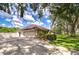 Spacious two-car garage and driveway, complemented by manicured greenery and garden at 17917 Clear Lake Dr, Lutz, FL 33548
