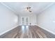 An empty living room with hardwood floors, white baseboards and crown molding, and French doors at 17917 Clear Lake Dr, Lutz, FL 33548