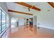 Open living room features wood flooring, exposed beams, and view to the outdoor screened-in pool at 17917 Clear Lake Dr, Lutz, FL 33548
