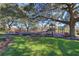 A community playground with mature trees and colorful play structures on a sunny day at 17917 Clear Lake Dr, Lutz, FL 33548