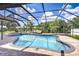 Screened-in pool area features a hot tub, seating area, and views of the serene lake at 17917 Clear Lake Dr, Lutz, FL 33548
