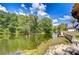 A serene waterfront view from the property with mature trees and landscaping at 17917 Clear Lake Dr, Lutz, FL 33548