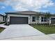 Charming single-story home with a gray garage door, landscaped yard, and a concrete driveway at 2026 Sidney St, Clearwater, FL 33763