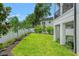Backyard showcases well-manicured lawn, tropical plants and a white fence at 2200 N Glenwood Dr, Tampa, FL 33602