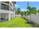 Backyard features a well-manicured lawn, tropical plants, and a white fence at 2200 N Glenwood Dr, Tampa, FL 33602