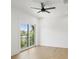 Airy bedroom with a ceiling fan, hardwood floors, and a large glass sliding door leading to a small balcony at 2200 N Glenwood Dr, Tampa, FL 33602