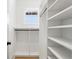 Well-organized walk-in closet with white shelving and black hardware, illuminated by natural light at 2200 N Glenwood Dr, Tampa, FL 33602
