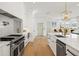 Bright white kitchen featuring stainless steel appliances, modern countertops, and a stylish gold pendant light fixture at 2200 N Glenwood Dr, Tampa, FL 33602