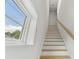 Bright staircase with natural wood steps and white risers with window view at 2200 N Glenwood Dr, Tampa, FL 33602