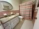This bathroom features a shower and granite vanity countertop with white cabinets at 2263 Americus E Blvd # 25, Clearwater, FL 33763
