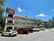 Well-maintained condominium building with balconies and ample parking under a clear, sunny sky at 2263 Americus E Blvd # 25, Clearwater, FL 33763
