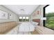 Light and airy main bedroom with modern furnishings, light wood flooring, and bright windows at 2301 N Ridgewood Ave, Tampa, FL 33602