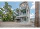 Unfinished three-story home with garage and a covered porch with a wood pergola frame under a cloudy sky at 2301 N Ridgewood Ave, Tampa, FL 33602