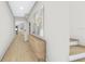Bright, spacious hallway with natural wood flooring, a dresser, an art print, and an open doorway to another room at 2301 N Ridgewood Ave, Tampa, FL 33602