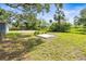 Large backyard featuring mature trees, partial fencing, and a concrete pad at 2305 N 48Th St, Tampa, FL 33605