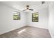 Bright bedroom with modern ceiling fan, two windows, and wood-look tile flooring at 2305 N 48Th St, Tampa, FL 33605