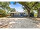 Single-story home with a blue front door, a screened in porch and a spacious unlandscaped front yard at 2305 N 48Th St, Tampa, FL 33605