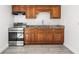 Well-lit kitchen featuring tile flooring, wooden cabinetry, granite countertops, and stainless-steel appliances at 2305 N 48Th St, Tampa, FL 33605
