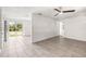 Open-concept living space features neutral walls, tile flooring, an adjacent doorway, and a glass sliding door at 2305 N 48Th St, Tampa, FL 33605