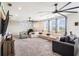 This room has gray carpet, neutral colored walls, a ceiling fan, bar area, and plenty of seating to relax at 2515 63Rd Ter E, Ellenton, FL 34222