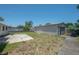 Backyard with a detached garage, small concrete patio, and partially fenced yard at 2614 E Liberty St, Tampa, FL 33612