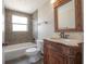 Bathroom featuring mosaic tiled walls, wood vanity, and a shower over tub at 2614 E Liberty St, Tampa, FL 33612