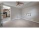 Bedroom showcasing neutral walls, carpet flooring, ceiling fan, and doorway leading to the kitchen at 2614 E Liberty St, Tampa, FL 33612