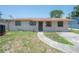 Modest single-story home with a walkway leading to the front door and bars on the windows at 2614 E Liberty St, Tampa, FL 33612