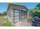 Exterior view of the garage featuring a secured door, roll-up door, and partial lawn mower at 2614 E Liberty St, Tampa, FL 33612