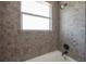 Shower over tub featuring neutral mosaic tile and dark bronze fixtures at 2614 E Liberty St, Tampa, FL 33612