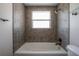 Shower over tub featuring neutral mosaic tile and dark bronze fixtures at 2614 E Liberty St, Tampa, FL 33612