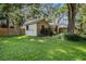 Spacious backyard featuring lush green grass, mature trees, and a wooden fence at 2838 Timber Knoll Dr, Valrico, FL 33596