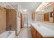 Tiled bathroom featuring a shower-tub combo and wood-finished vanity cabinet at 2838 Timber Knoll Dr, Valrico, FL 33596