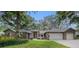 Charming brick home with a well-manicured lawn, mature trees, and a two-car garage at 2838 Timber Knoll Dr, Valrico, FL 33596