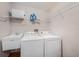 Functional laundry room with white washer and dryer, sink, and storage shelves at 2838 Timber Knoll Dr, Valrico, FL 33596