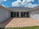 Back patio with brick flooring and string lights, attached to home via sliding glass doors at 30017 Johnston Rd, Dade City, FL 33523