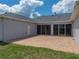 Back patio with brick flooring and string lights, attached to home via sliding glass doors at 30017 Johnston Rd, Dade City, FL 33523