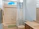 Clean bathroom with tiled tub/shower, decorative shower curtain, and wood-style cabinet at 30017 Johnston Rd, Dade City, FL 33523