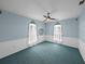 Blue bedroom featuring a ceiling fan, teal carpet, and heart mirror at 30017 Johnston Rd, Dade City, FL 33523