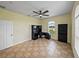 Bright bedroom with ceiling fan, desk, tile floors, and arched windows with backyard view at 30017 Johnston Rd, Dade City, FL 33523