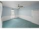 Blue bedroom featuring a ceiling fan, teal carpet, and white door at 30017 Johnston Rd, Dade City, FL 33523