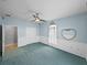 Blue bedroom featuring a ceiling fan, teal carpet, and white closet doors at 30017 Johnston Rd, Dade City, FL 33523