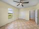 Inviting bedroom with arched window, double closet, ceiling fan and tile flooring at 30017 Johnston Rd, Dade City, FL 33523